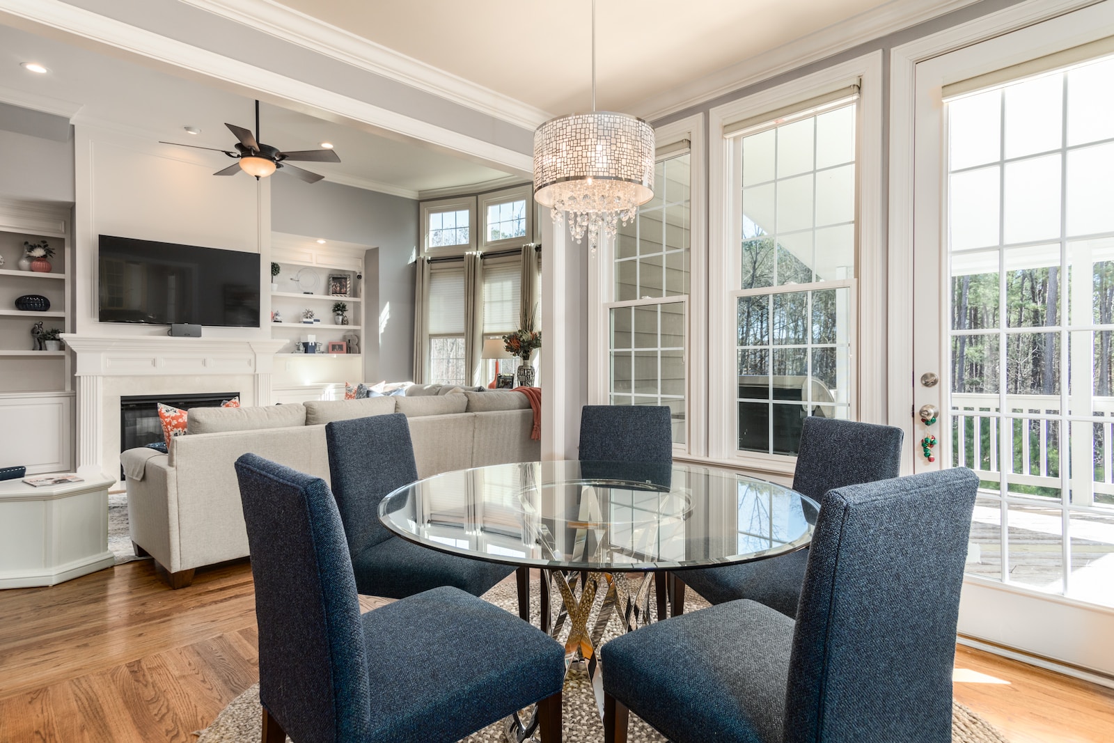 round clear glass-top table and five gray chairs dining in home